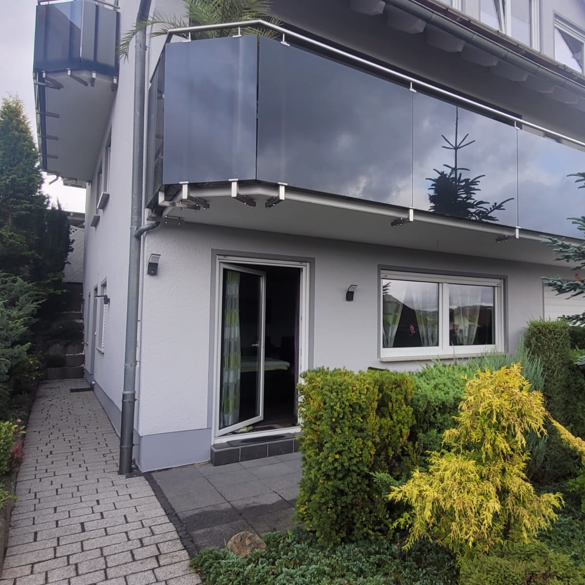 Blick auf die Terasse von der Straße aus. Der Wohnungseingang ist links.